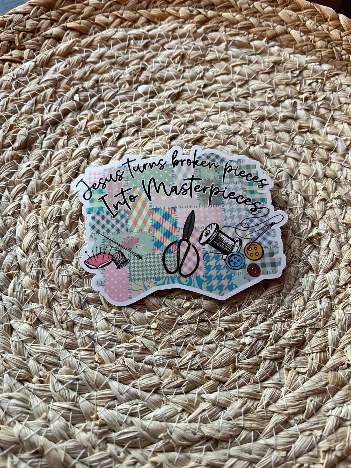 Decorative sticker with sewing-themed design on a woven surface