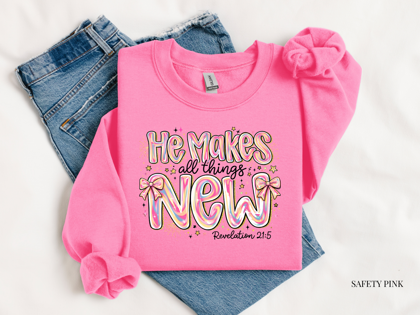 Pink sweatshirt with colorful text and denim jeans on a white background
