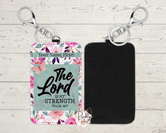 Floral design keychain with 'The Lord is my strength' text on a wooden surface