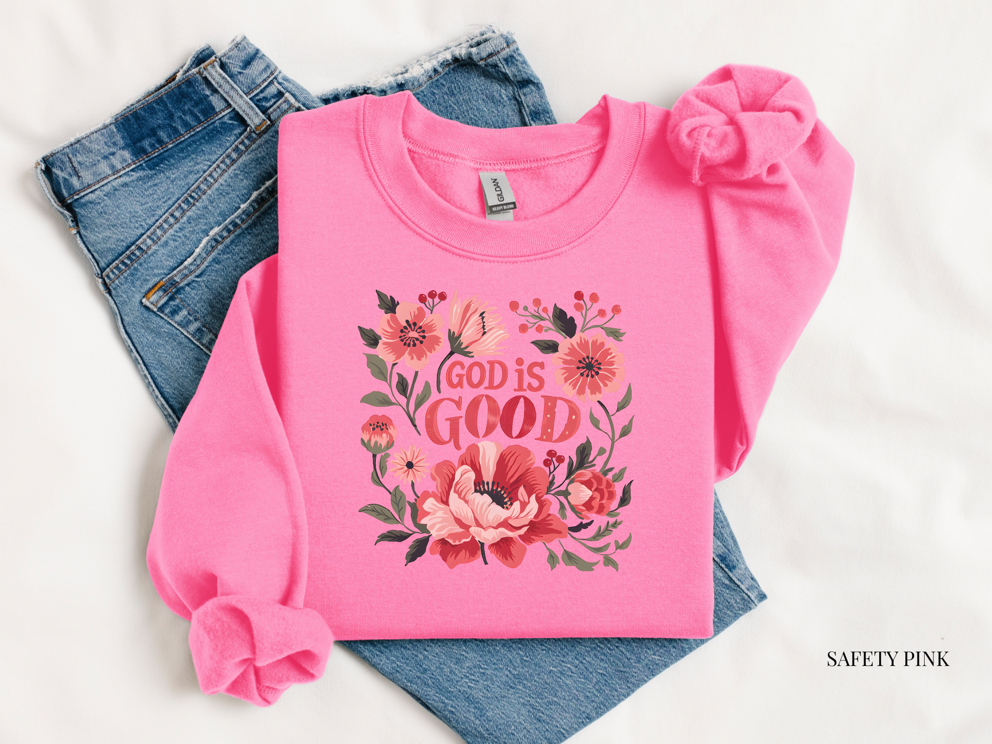 Pink sweatshirt with floral design and 'God is Good' text on a white background