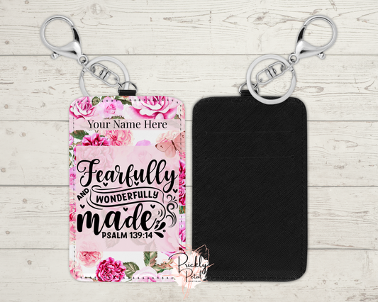 Floral keychain with 'Fearfully and Wonderfully Made' text on a wooden surface
