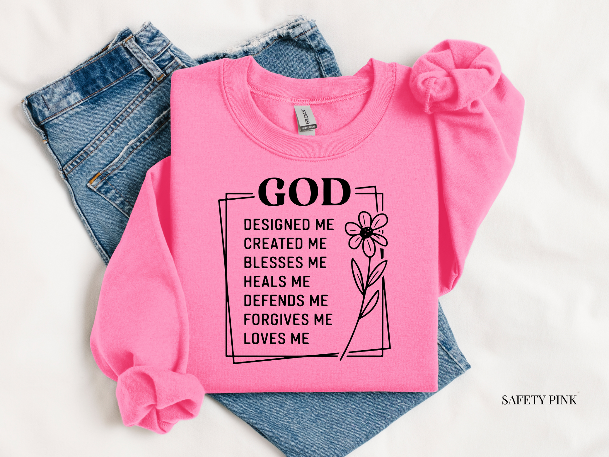 Pink sweatshirt with text and a flower graphic on a white background
