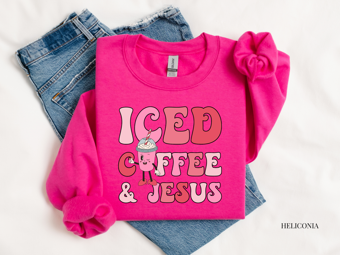 Pink sweatshirt with 'ICED COFFEE & JESUS' text and graphics on a white background