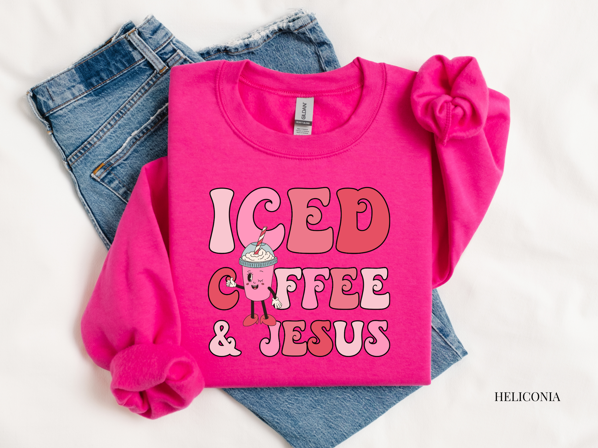Pink sweatshirt with 'ICED COFFEE & JESUS' text and graphics on a white background