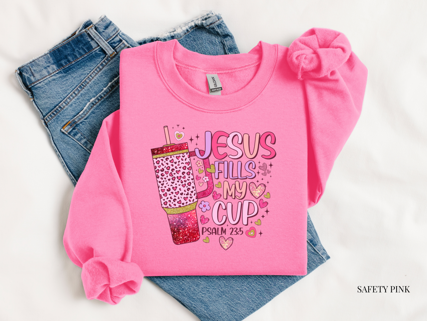 Pink sweatshirt with 'Jesus Fills My Cup' text on a white background
