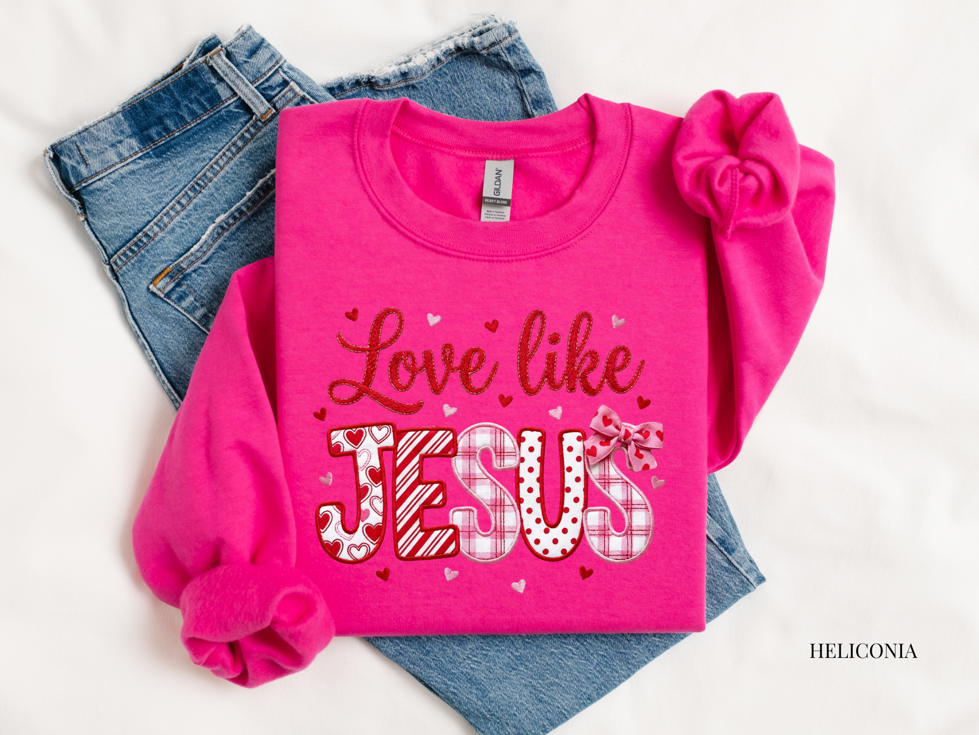 Pink sweatshirt with 'Love like Jesus' text on a white background