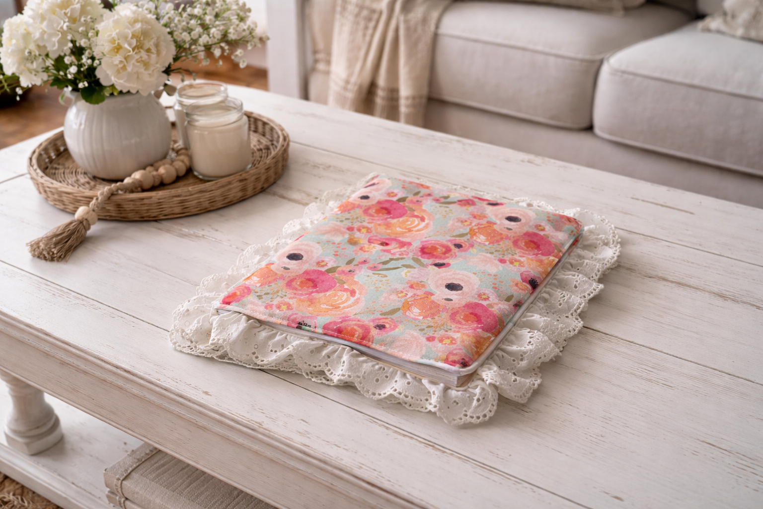 Floral-patterned bible cover on a white wooden coffee table with decorative items.