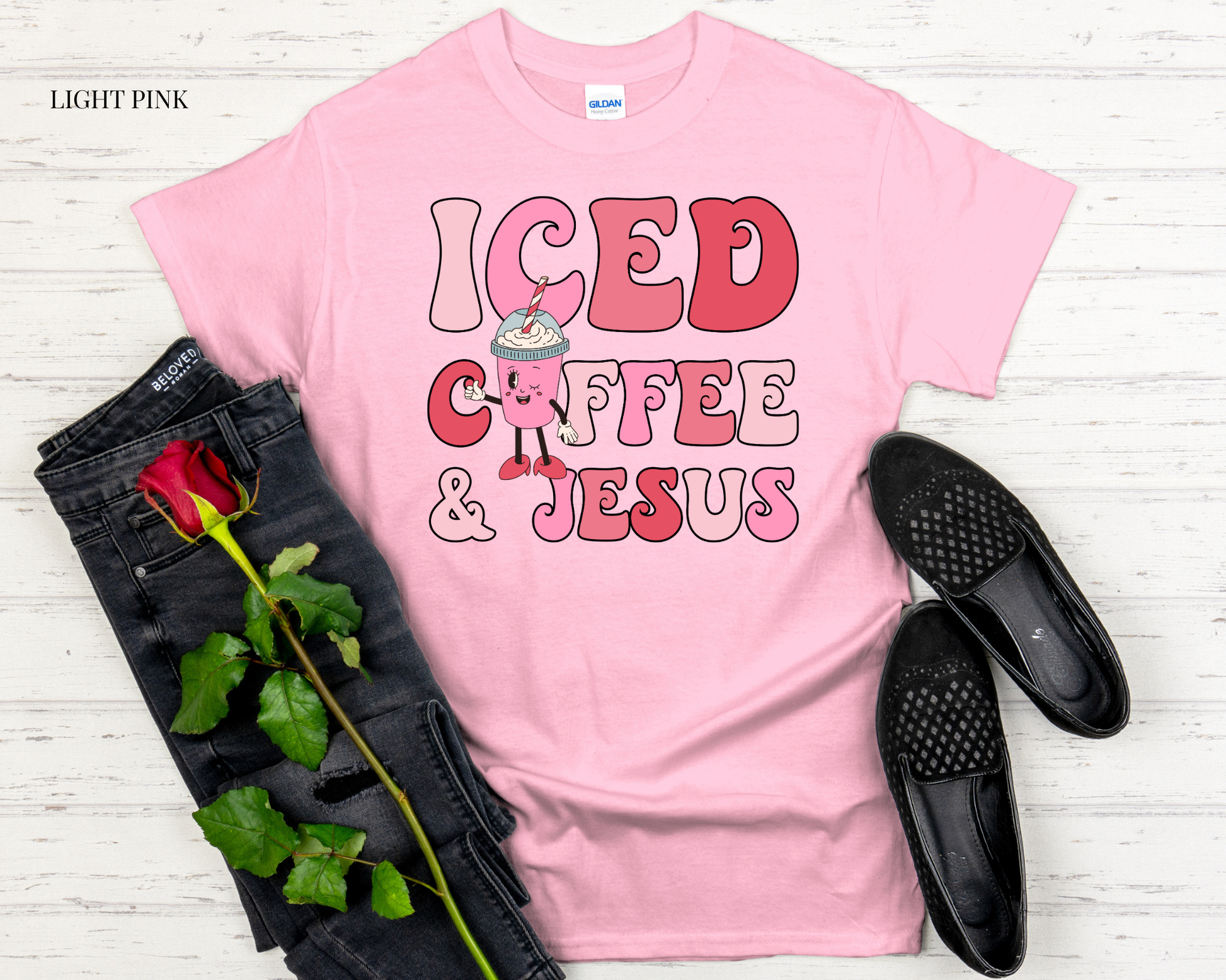 pink t shirt with design with black jeans and white background