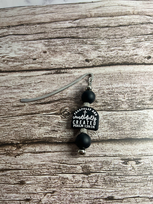 Black and silver hair clip with a heart-shaped label on a wooden surface