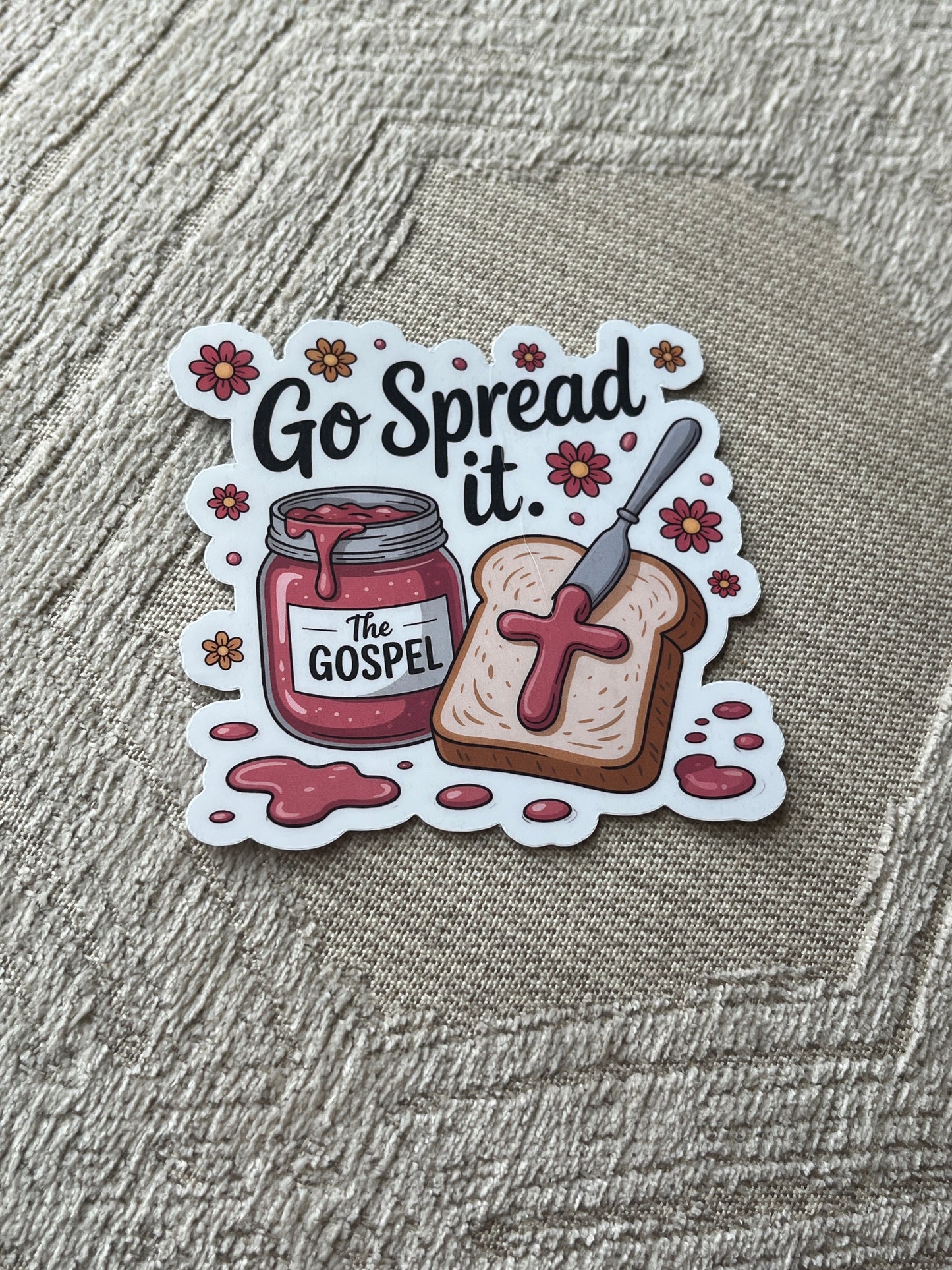 Sticker with a design of toast, jelly, and a knife with text 'Go Spread it. The Gospel'