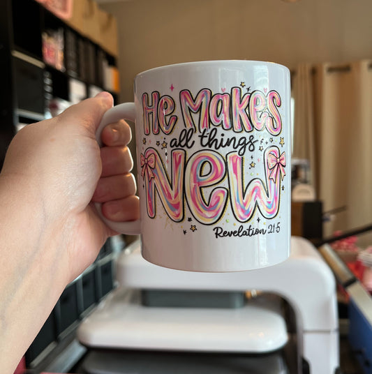 Hand holding a mug with colorful text in a kitchen setting