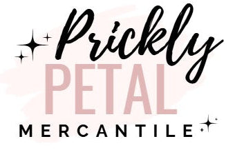 A logo-style graphic reading 'Prickly PETAL MERCANTILE' on a white background, with black script and block text over soft pink watercolor shapes and small black sparkle icons.