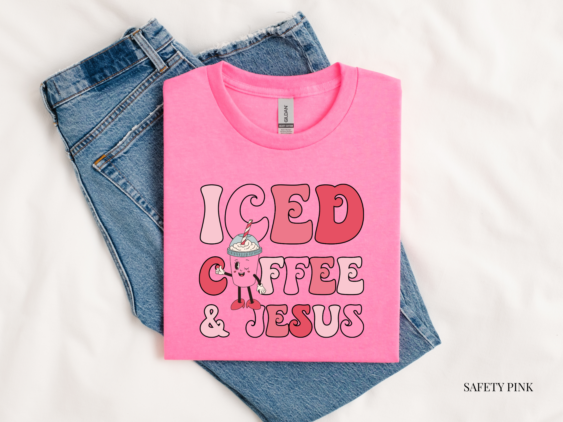 iced coffee and Jesus pink tshirt against blue jeans and white background
