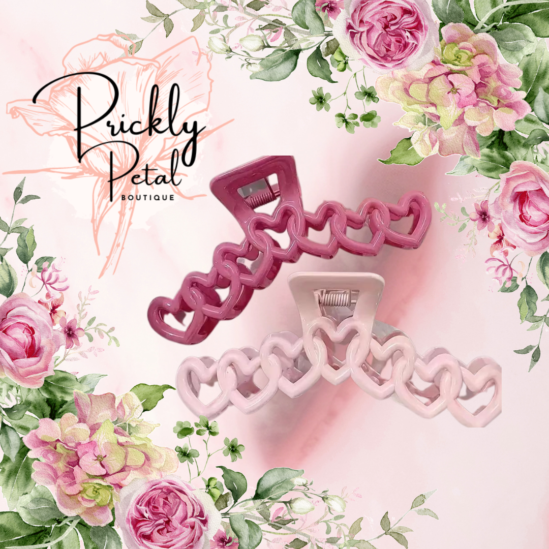 A set of hair clips designed with heart shapes, presented on a background with floral illustrations.