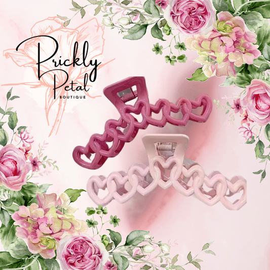 A set of hair clips designed with heart shapes, presented on a background with floral illustrations.